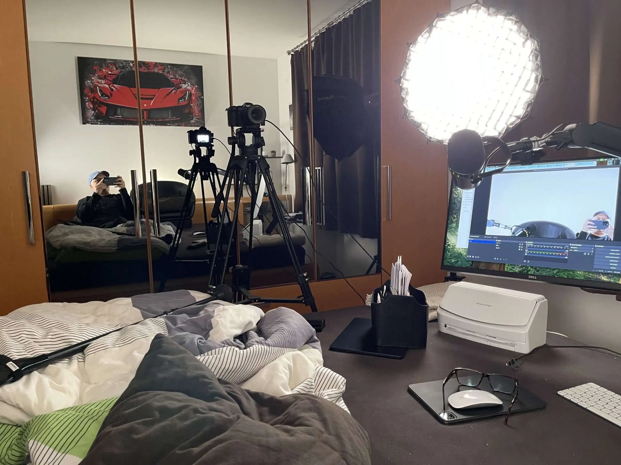 Nadeem Arif's room with cameras, a softbox light and a monitor set up around the bed